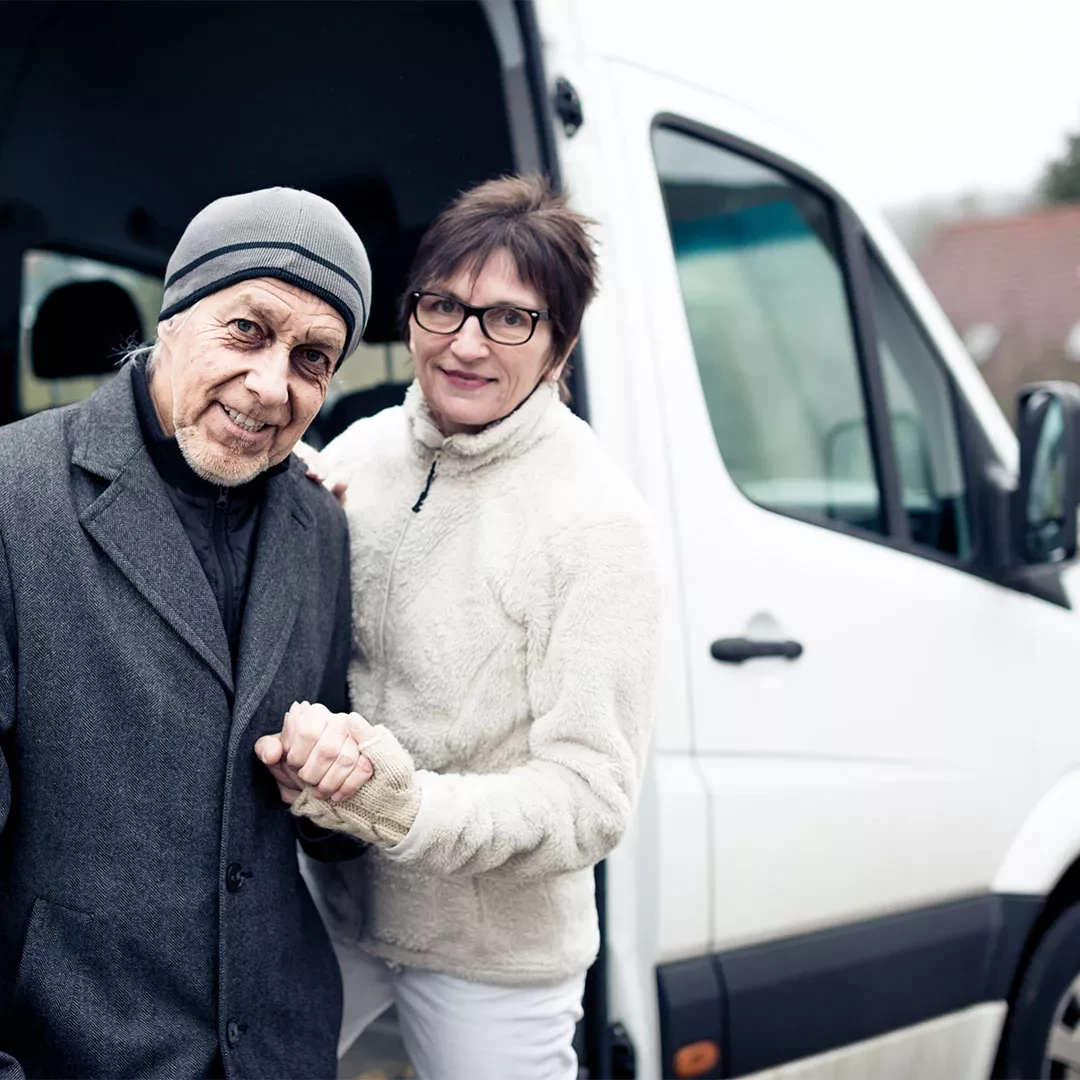 Caregiver assisting passenger out of a vehicle