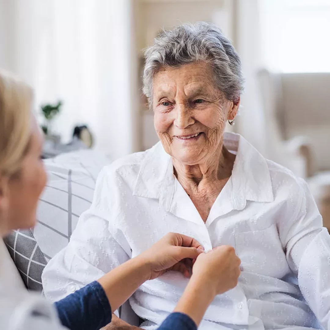 Older woman being assisted by a nurse