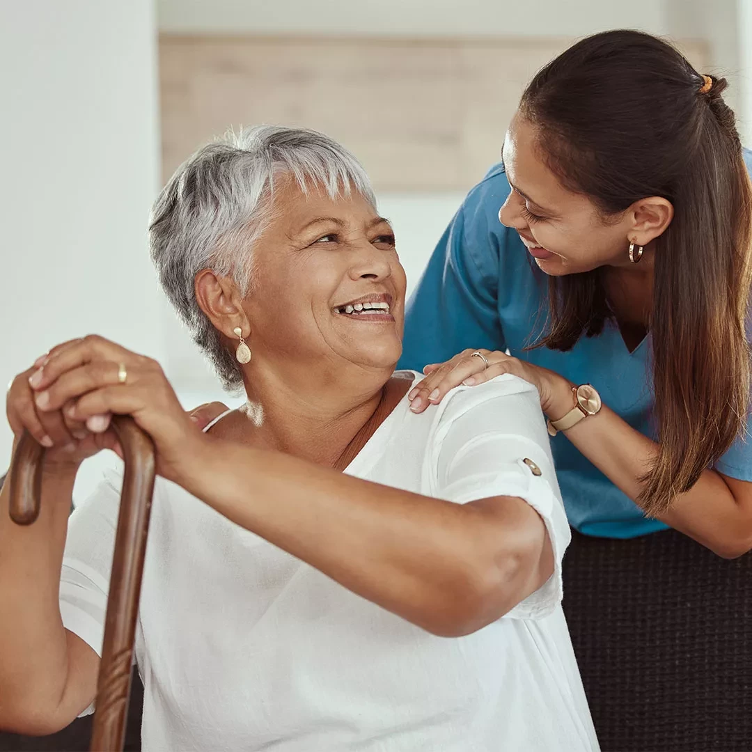 Caregiver helping an older lady with a cane