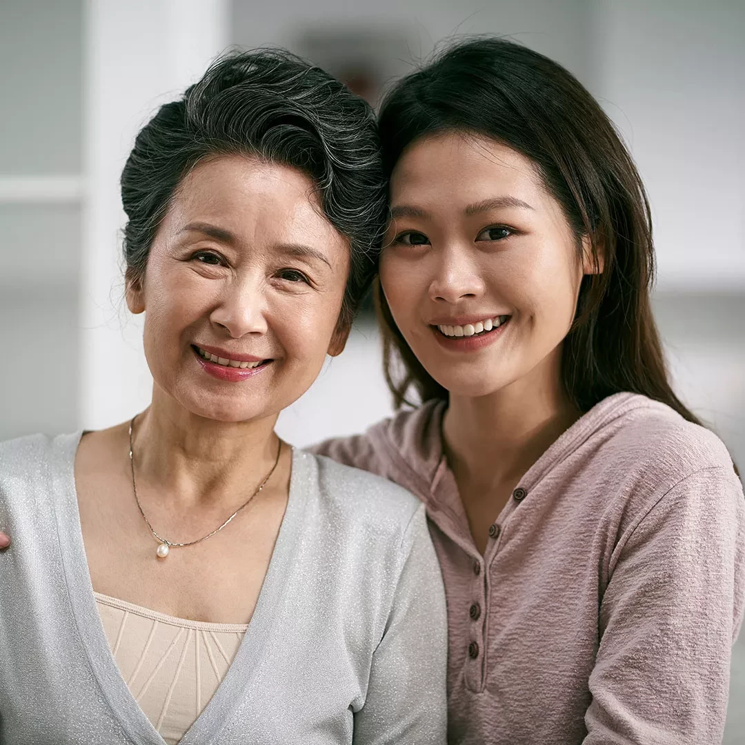 Younger and older women smiling together