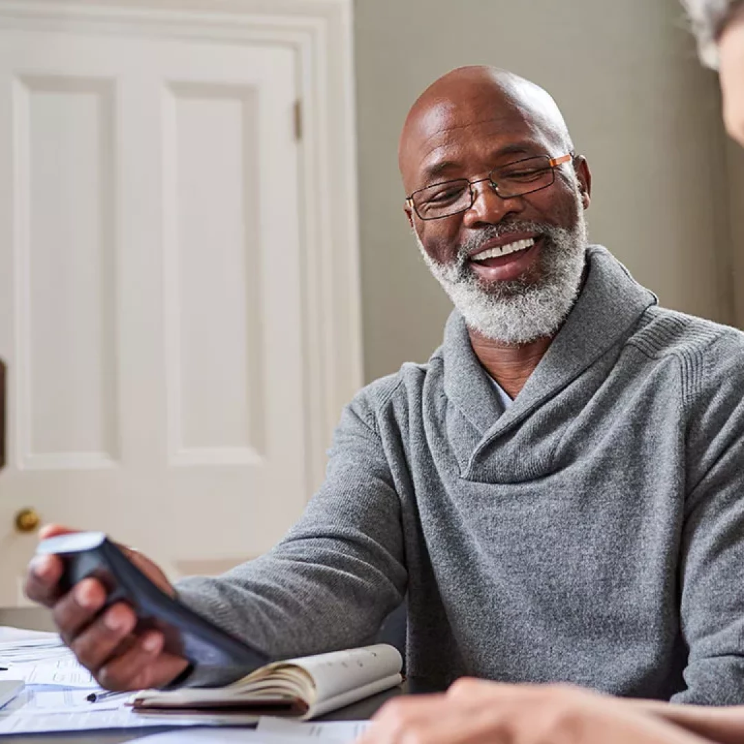 Older man with gray beard using his phone