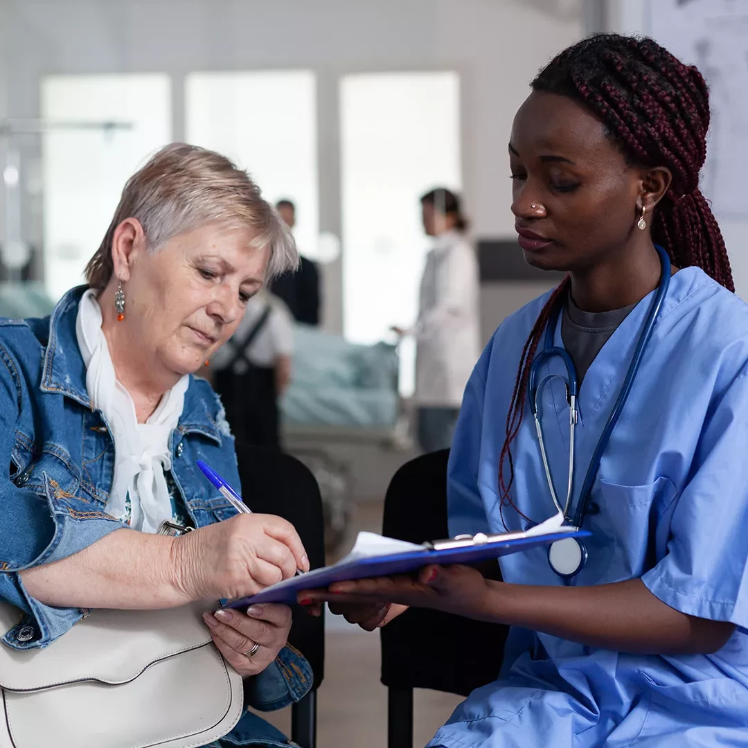 Patient signing forms for a nurse in scrubs