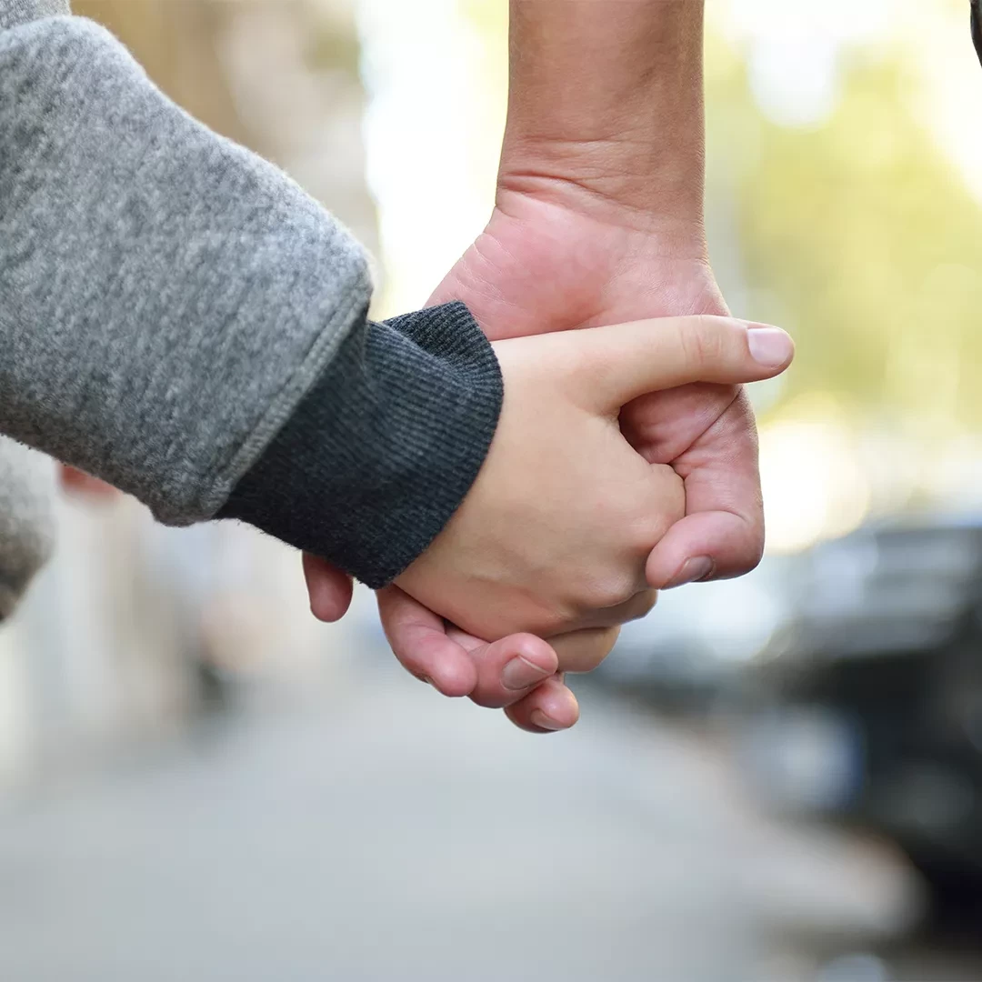 Older person holding hands with a child