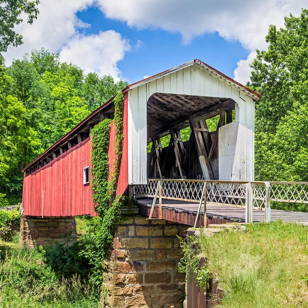 Old red and white bridge with moss