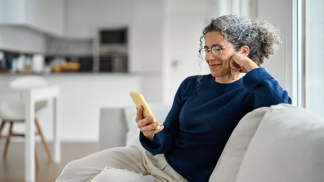 Woman sitting on a couch looking at her phone